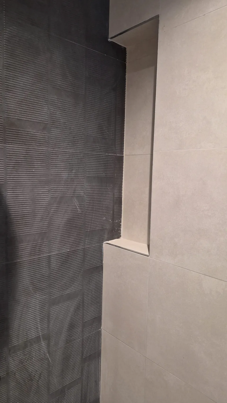 Gri banyo duvarında seramik derzleri ve köşe bitişlerinin yakından görünümü