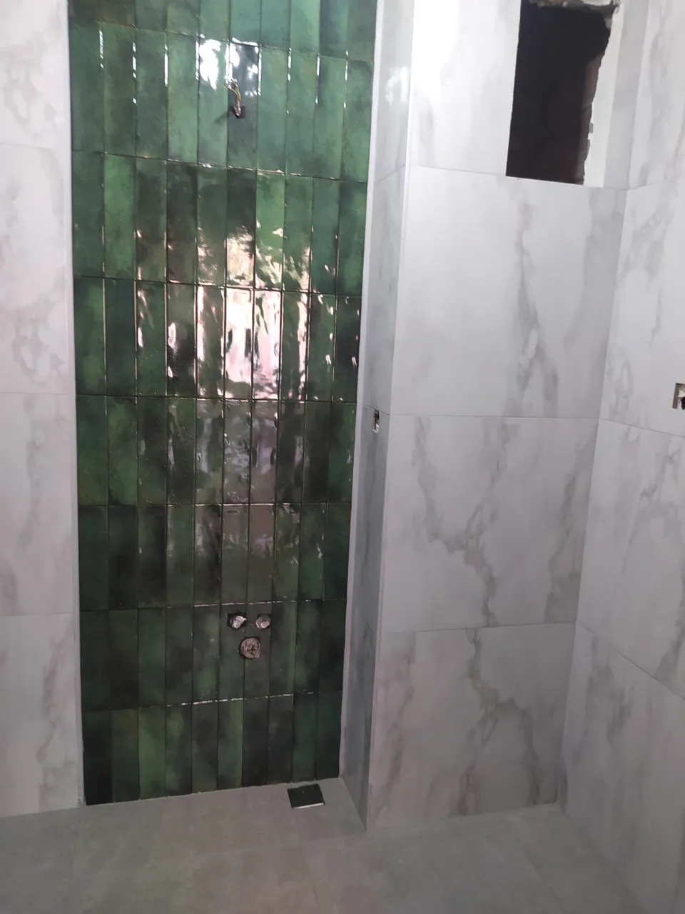 Yeşil parlak seramiklerin dikey döşendiği banyo duvarı detayı
